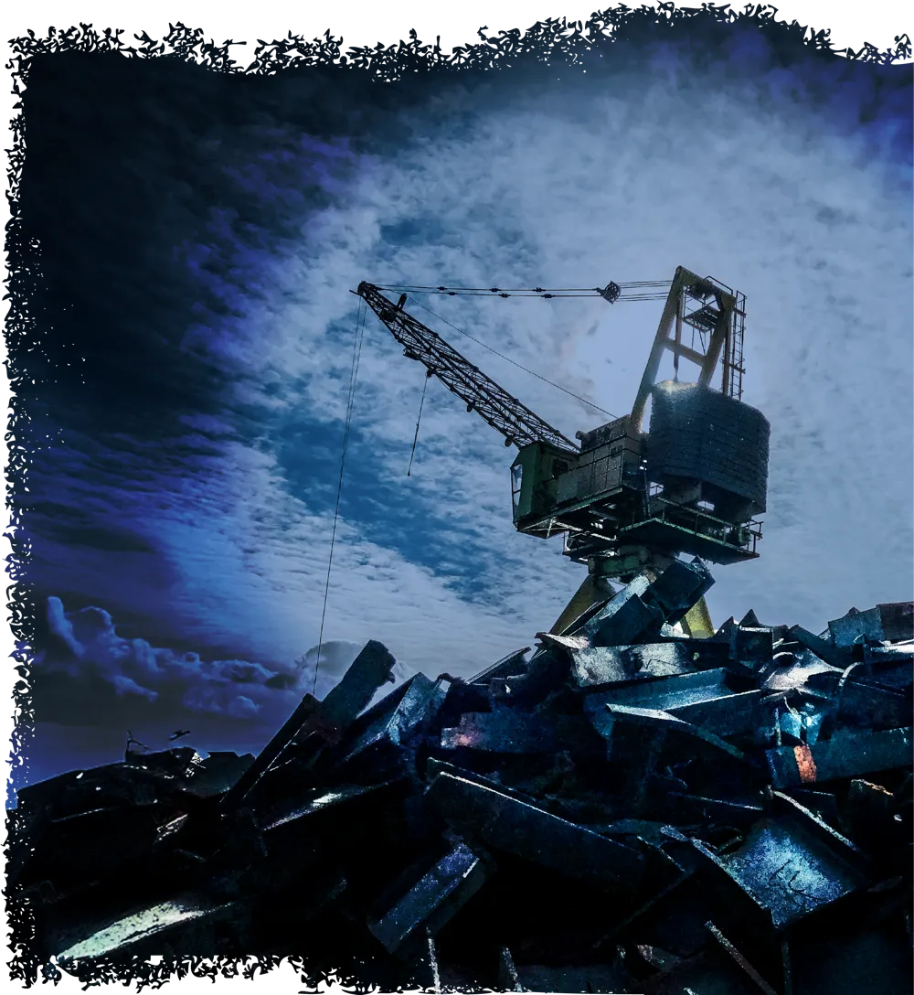 A crane above a pile of scrap metal under a cloudy sky.